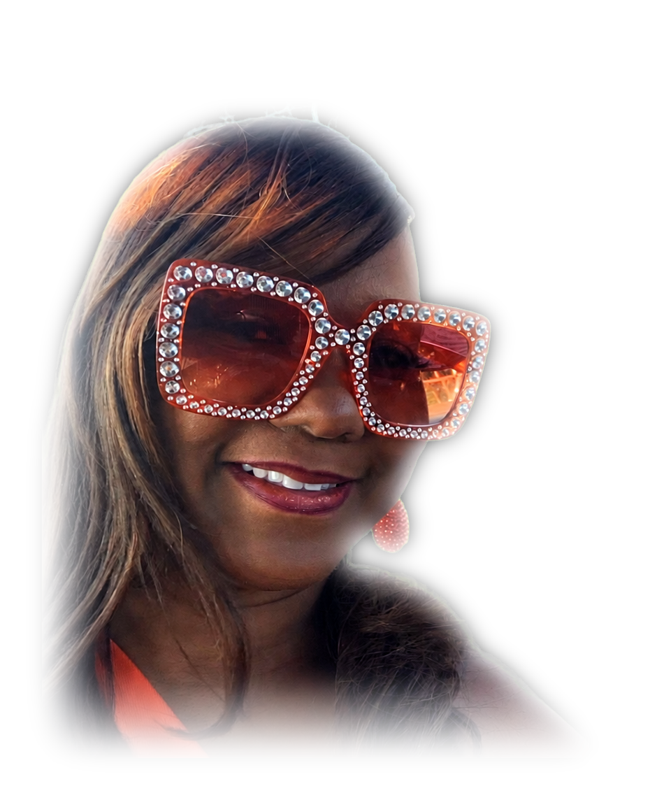 Sherrie Hazely smiling in an orange dress and oversized rhinestone sunglasses